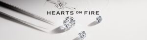 Hearts On Fire logo above 3 diamonds sitting on a white surfac